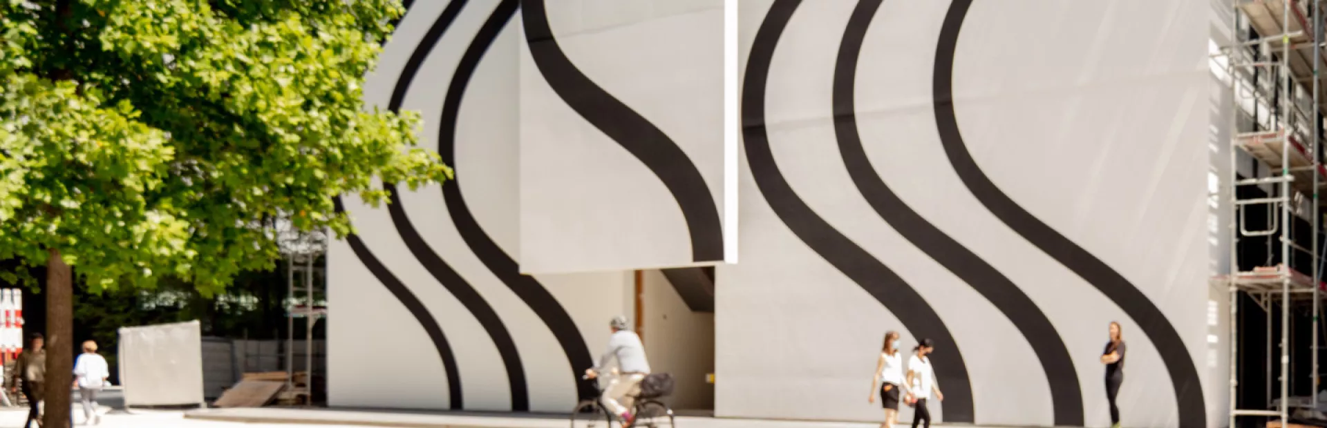 A large, 60 meter-tall wall mural with curved black lines on a white background