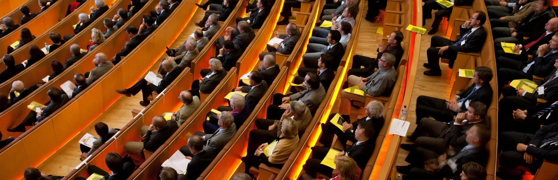 A crowd of seated people at a speaker event inside an auditorium