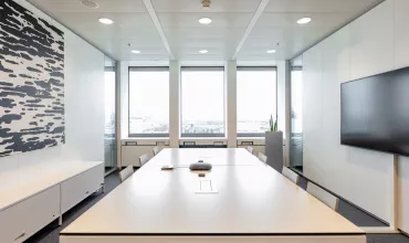 A bright meeting room with a large table in the center