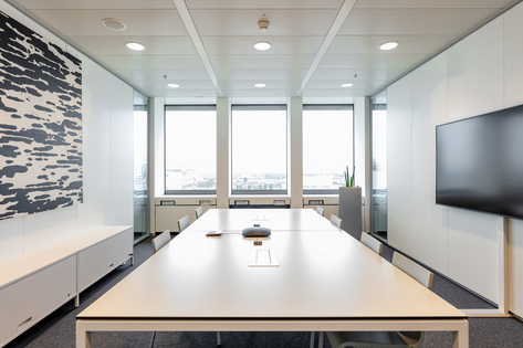 A bright meeting room with a large table in the center