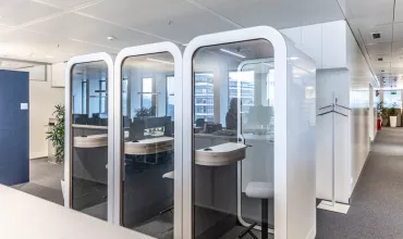 A row of individual work pods with seating and desk spaces inside