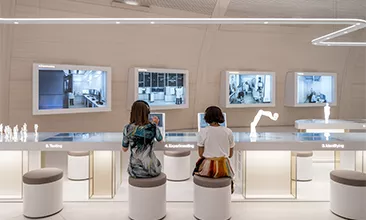 People sitting in the interactive exhibition of the Novartis Pavillon