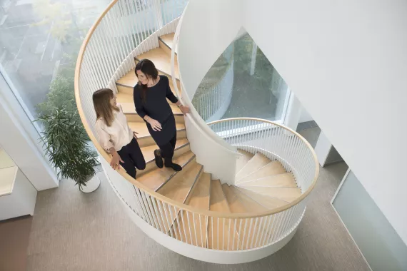 Two people in discussion while walking down a spiral staircase